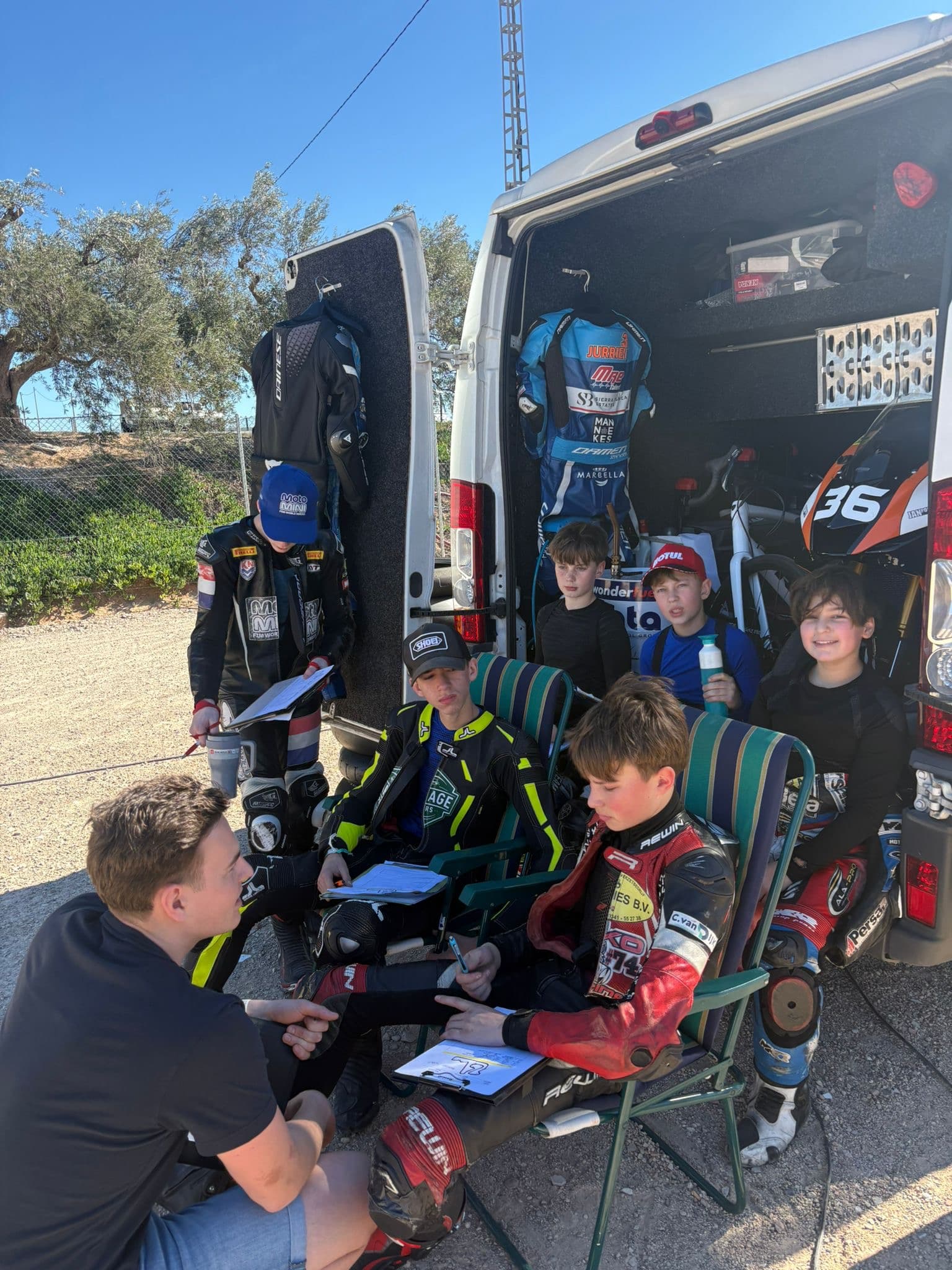 Coach bespreekt de sessie met een groep jonge coureurs